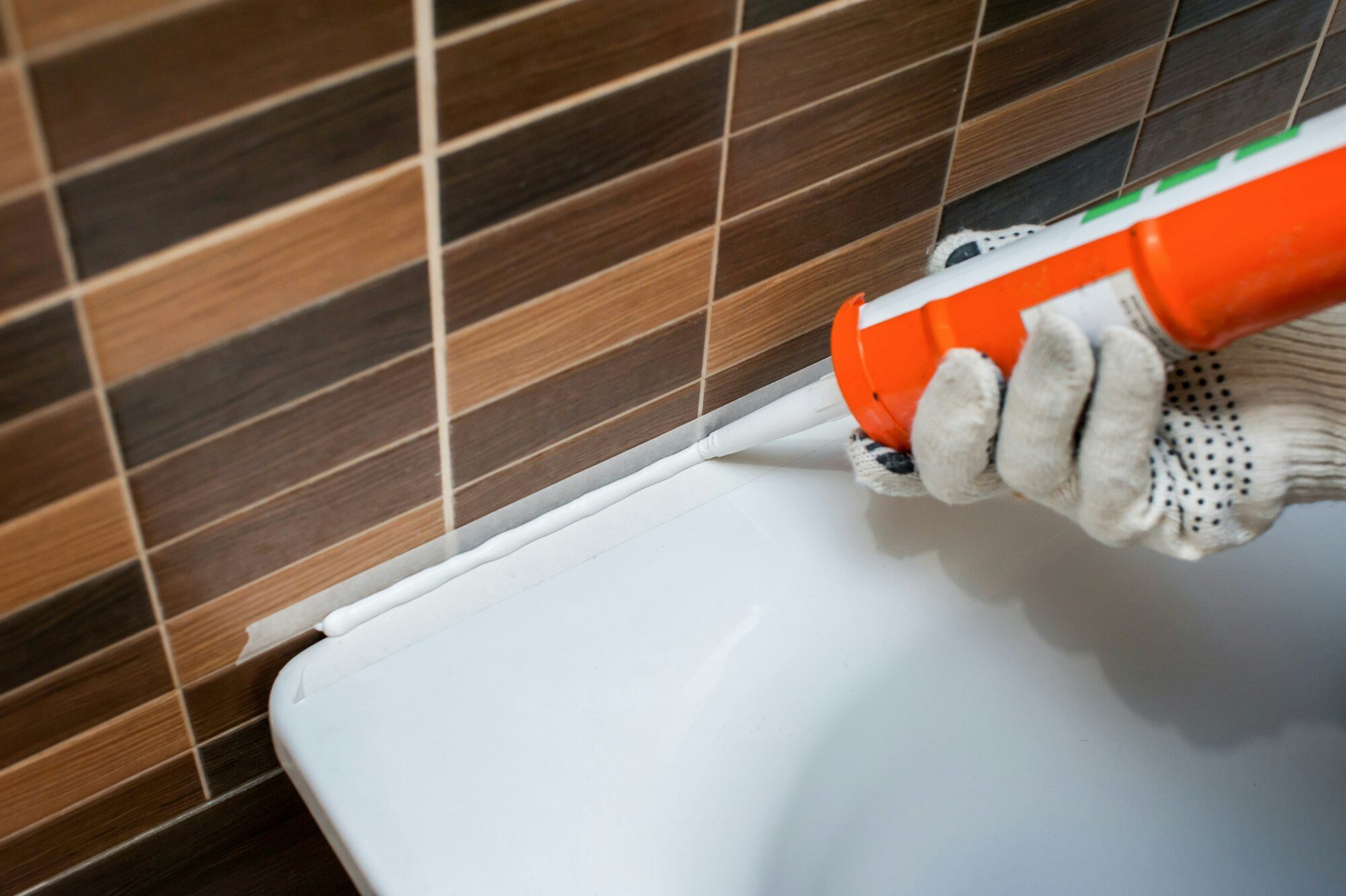 sealing cracks in the bathroom with silicone sealant